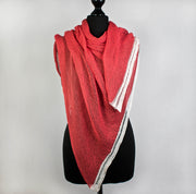 Locker gestricktes, leicht transparentes Sommertuch aus Baumwolle in Farbe Koralle, das auf der Flachstrickmaschine von Hand gefertigt wurde.